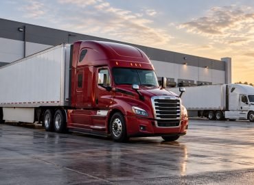 Red and white semi trucks at a logistics yard illustrating trucking working capital financing